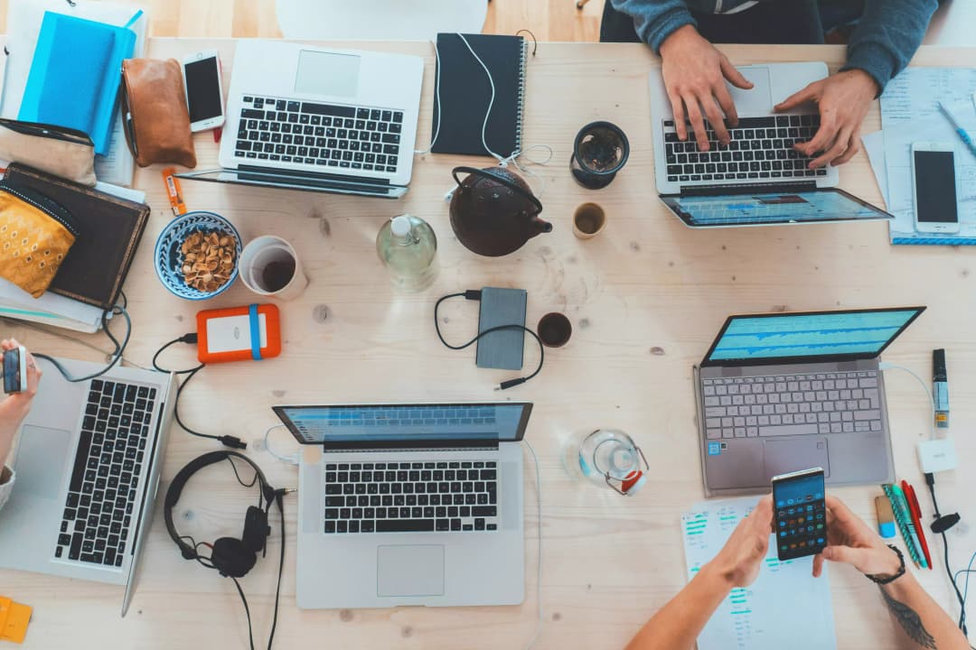 Équipe de développeurs travaillant sur des projets collaboratifs avec plusieurs ordinateurs portables