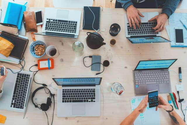 Équipe de développeurs travaillant sur des projets collaboratifs avec plusieurs ordinateurs portables