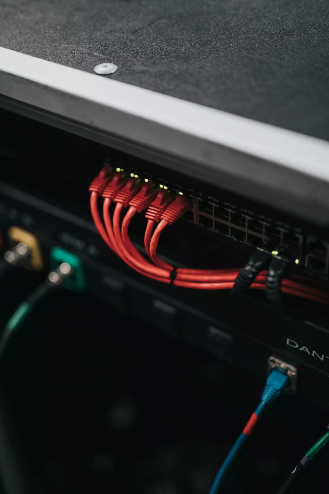 Technicien configurant un switch réseau avec câblage fibre optique