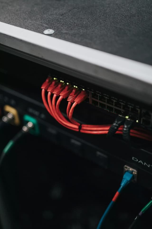 Technicien configurant un switch réseau avec câblage fibre optique